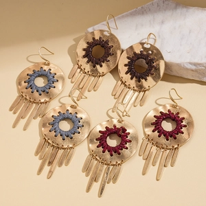 Boucles d'oreilles bohèmes dorées creuses avec tissage fait main et pompons métalliques