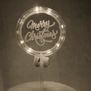 Close-up of LED glowing acrylic cake topper with Merry Christmas engraving and battery box