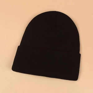 Detailed close-up of the fine knit texture and black fabric of this winter beanie hat