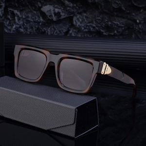 Retro tortoise square frame sunglasses with gold metal accents on a black leather case