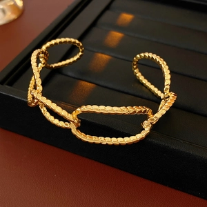 Close-up of gold-plated hollow woven texture irregular oval bracelet on jewelry tray