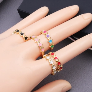 Detailed close-up of colorful enamel star rings with zircon inlay on a model's hand