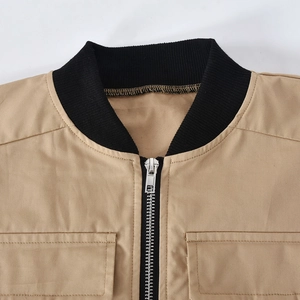 Close-up of khaki utility vest showing black ribbed collar and silver metal zipper detail