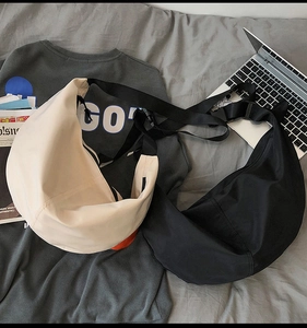 Flat lay of nylon messenger bags in beige and black with adjustable straps