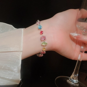 Macro detail of multicolored gemstone bracelet featuring square and round zircon settings