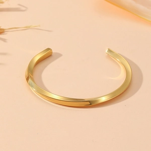 Polished gold stainless steel twisted bangle bracelet with elegant minimalist C-shape design
