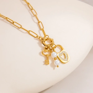 Elegant gold paperclip chain necklace with heart lock, key pendant and white pearls