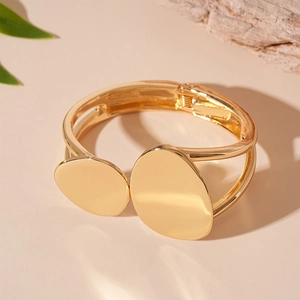 Close-up of golden metallic irregular geometric double layer bangle with spring hinge