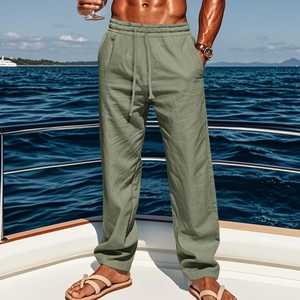Detail of sage green linen trousers featuring a drawstring elastic waist for casual style