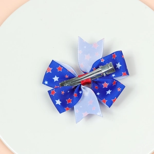 Detail of red, white and blue bow hair clip with star pattern and metal alligator grip