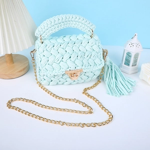 Vue détaillée du sac bandoulière en crochet vert menthe avec chaîne dorée et gland charmant.