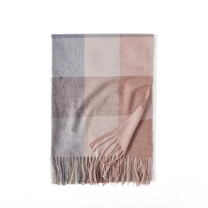 Soft faux cashmere scarf with a plaid pattern in grey and orange, featuring tassel edges