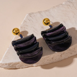 Macro detail of dark purple resin geometric earrings with gold studs and glitter finish