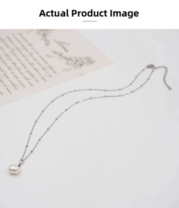 Detail of a minimalist freshwater pearl necklace with silver chain and a Love gift card