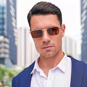 Classic men's rectangular sunglasses with gold metal frames and brown lenses worn by model