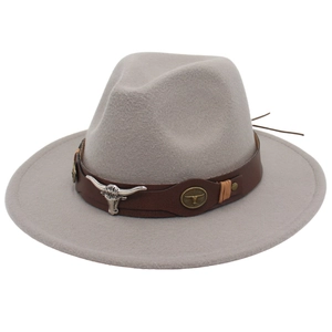 Détail d'un chapeau feutre gris avec ruban en cuir brun et emblème de tête de taureau