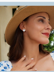 Classic S925 sterling silver heart-shaped hoop earring worn by a model in outdoor light