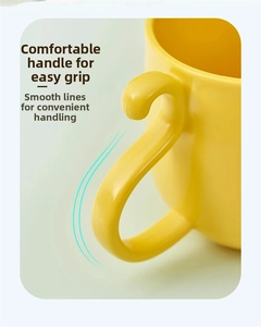 Close-up of bright yellow cartoon cup featuring an ergonomic handle and smooth matte finish