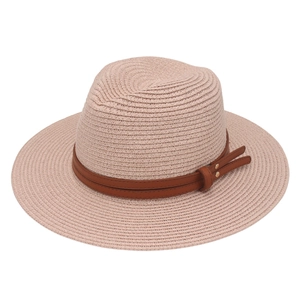 Detail of light pink woven straw hat featuring brown leather band and gold stud accents