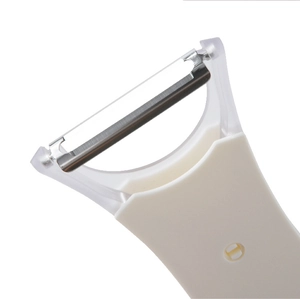 Close-up of a stainless steel blade on a white plastic kitchen fruit vegetable peeler