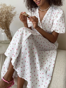 Vue détaillée d'une robe en coton à col en V et manches bouffantes blanche avec fleurs roses