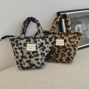Detailed view of plush leopard print handbags in grey and brown faux fur textures
