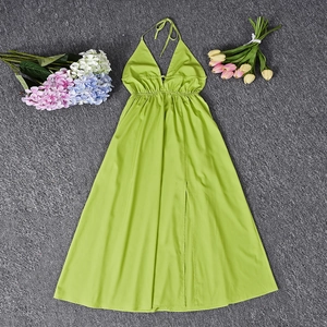 Flat lay of lime green backless halter maxi dress with high slit and floral accents