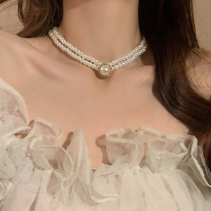 Détail du collier de perles baroques à double rangée avec grand pendentif doré