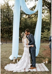 Close-up of light blue chiffon fabric draped elegantly for outdoor wedding arch decor