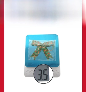 Macro shot of green Christmas ribbon bows with festive prints on a precision scale