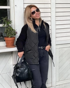 Detail of black diamond-quilted vest featuring a stand collar and full-zip closure