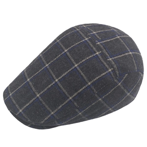 Close-up of the grey plaid wool fabric texture and stitching on the newsboy flat cap