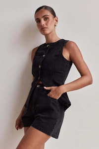 Dettaglio del set due pezzi in denim nero con top senza maniche bottoni e pantaloncini