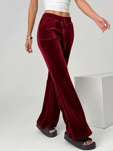 Detailed side view of high-waist burgundy velvet flare pants with tie-waist detail