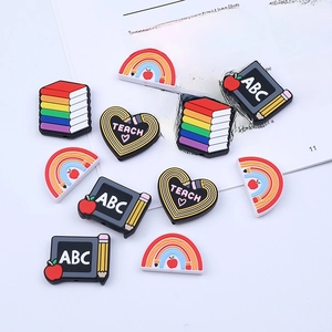 Rainbow pencil and school theme PVC shoe charms for DIY school accessories on white surface