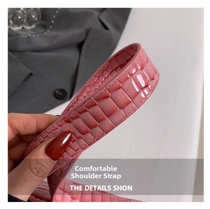 Detail of a pink gradient faux-crocodile leather strap with a glossy finish on handbag