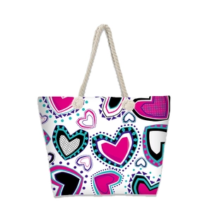 Detailed view of woven rope handles on a large canvas tote bag with heart pattern