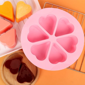 Close-up van roze 6-holte hart siliconen mal voor het bakken van cakes en gelei met product