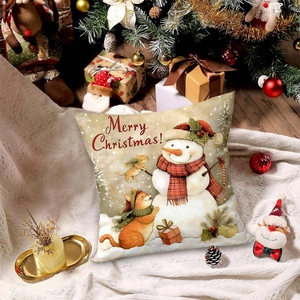 Weihnachtskissenbezug mit Schneemann und Katze auf einer gemütlichen weißen Decke liegend