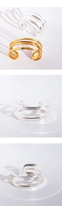 Detail of multi-layer geometric open cuff bracelet in gold and silver polished metal