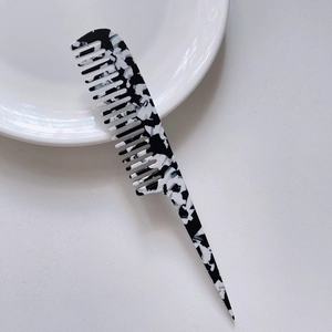 Close-up of anti-static tail comb with elegant black and white marble acetate texture