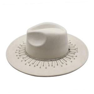 Close-up of wide brim fedora with sparkling rhinestone fringe detail on beige suede