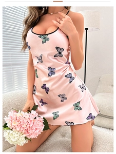 Detail of pink silk satin slip dress with butterfly prints and black trimmed neckline