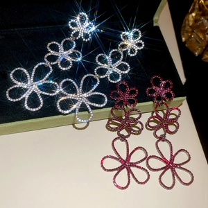 Detailed macro of hollow flower tassel earrings with crystals in silver and red