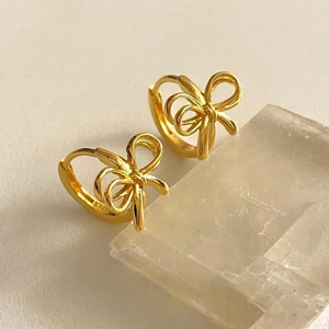 Detail of gold butterfly bow earrings in S925 sterling silver on mineral stone