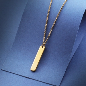 Minimalist gold rectangular bar pendant necklace with mirror finish on dark blue background