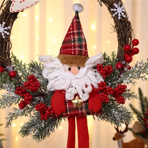 Detail of Christmas wreath featuring Santa plush, natural vines, and snow-dusted pine branches