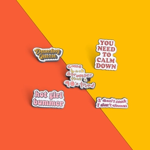 Detailed view of five colorful enamel pins with motivational slogans on a split background
