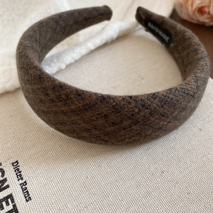 Dettaglio cerchietto in tweed marrone scuro con etichetta fatta a mano su tela