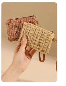 Detail of woven straw coin purses in beige and brown with wristlet strap and zipper